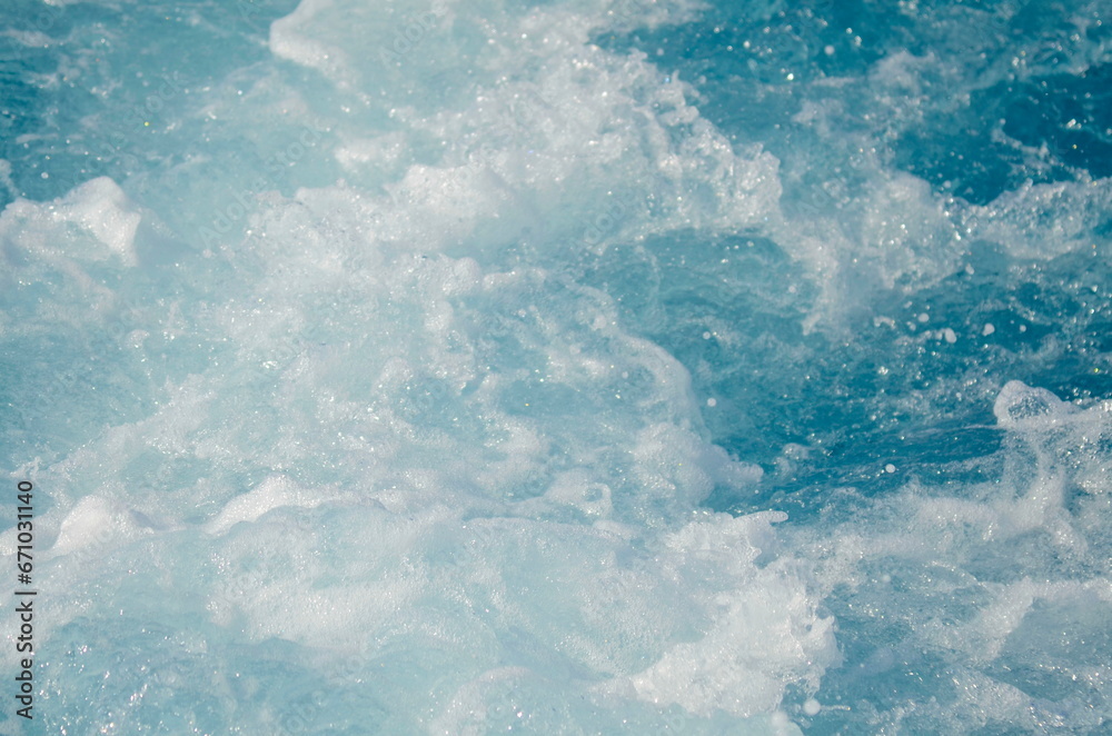 Obraz premium Stormy sea, strong waves. A trace on the sea from a boat or yacht. Ocean close-up, beautiful water color