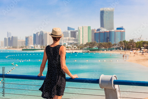Obraz na płótnie Tourist woman in Abu Dhabi, UAE. Sea, beach and skyscrapers background w salonie