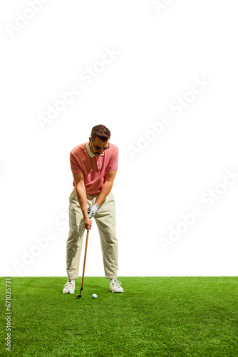 Young man golf player in red t-shirt taking swing, on golf course on green grass at golf club.