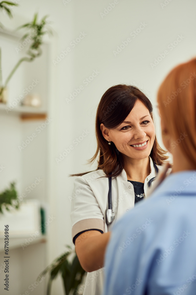 Portrait of a smiling female doctor, examining a female patient, having thyroid gland control. Portrait of a smiling female doctor, examining a female patient, having thyroid gland control.