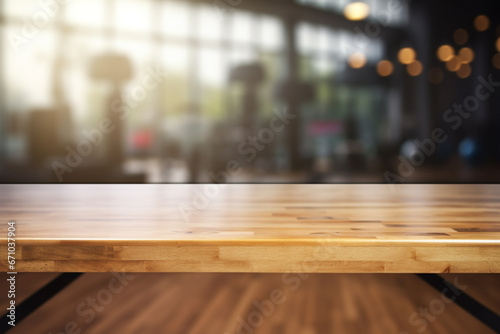 Top of surface wooden table with blurred fitness gym   background. © Golden House Images