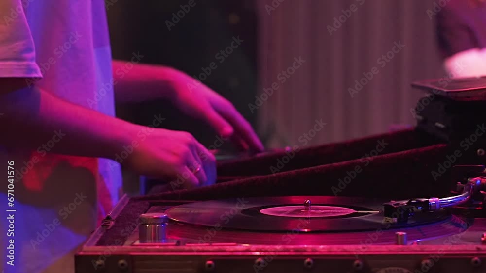 DJ at a party spins records with his hand. Close-up of a DJ working. Dancing and music at the event. DJ console DJ at a party spins records with his hand. Close-up of a DJ working. Dancing and music at the event. DJ console