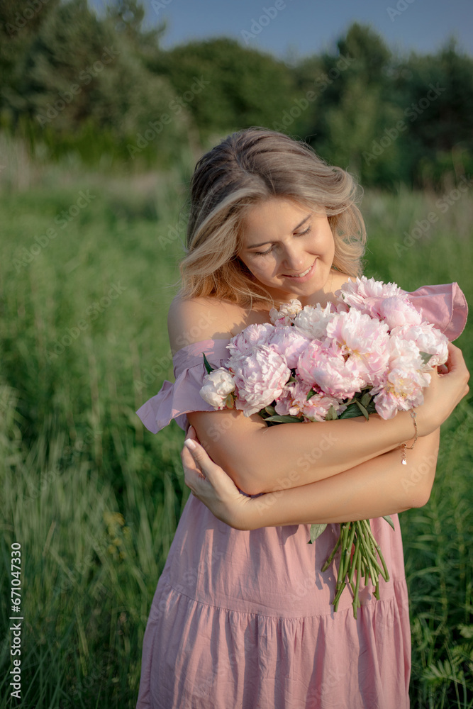 Fototapeta premium Natural cosmetics for skin care. Lovely blonde in dress stands with bouquet of peonies in nature.