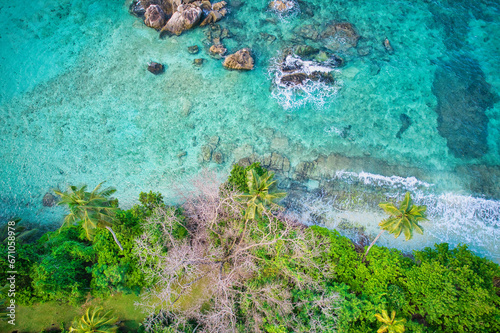 Fototapeta Naklejka Na Ścianę i Meble -   Bird eye drone of Port Glaud beach, granite stones, white sandy beach, turquoise water, coconut palm, greenery, trees, sunny day, Mahe Seychelles