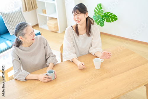Bild auf Leinwand 部屋で仲良く話すシニア女性と若い女性