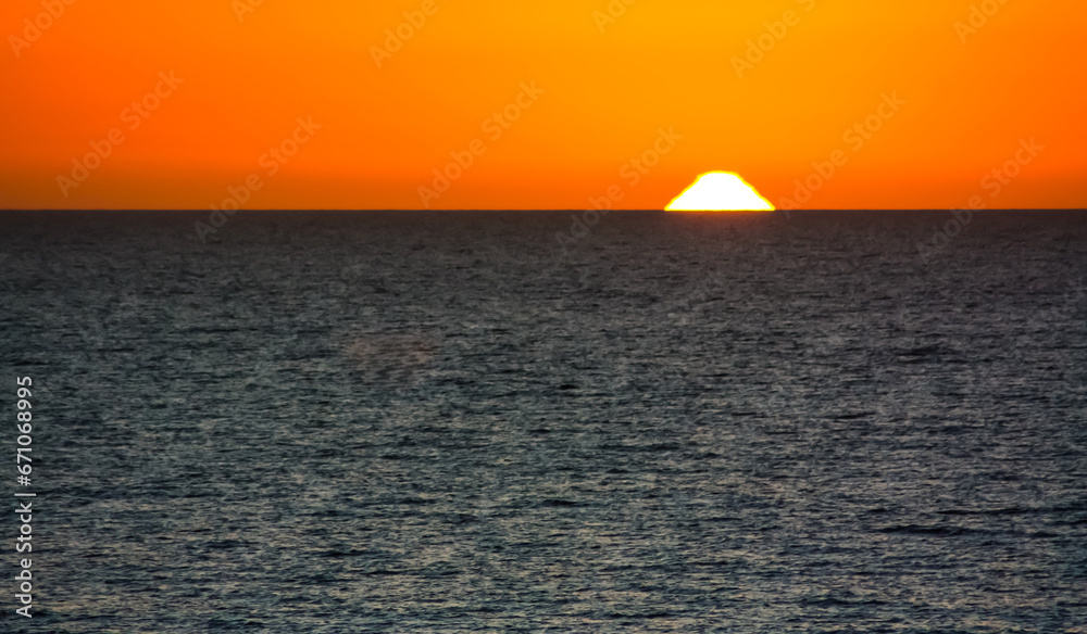 A misshapen sun sinking into the Gulf of Mexico off the Island of Anna Maria, Florida.
