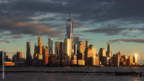 New York City skyline at sunset with World Trade Center skyscrapers from the Hudson River. Financial District of Lower Manhattan timelapse
