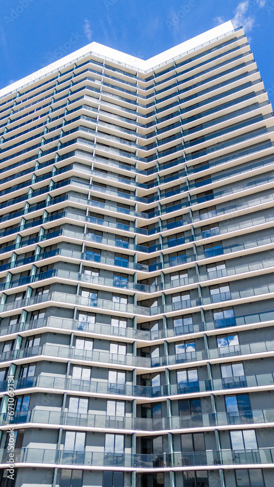 Cropped bottom view of remarkable super-tall building with modern exterior on sunny day. Vertically oriented design of architectural construction utilizing technological advances Cropped bottom view of remarkable super-tall building with modern exterior on sunny day. Vertically oriented design of architectural construction utilizing technological advances