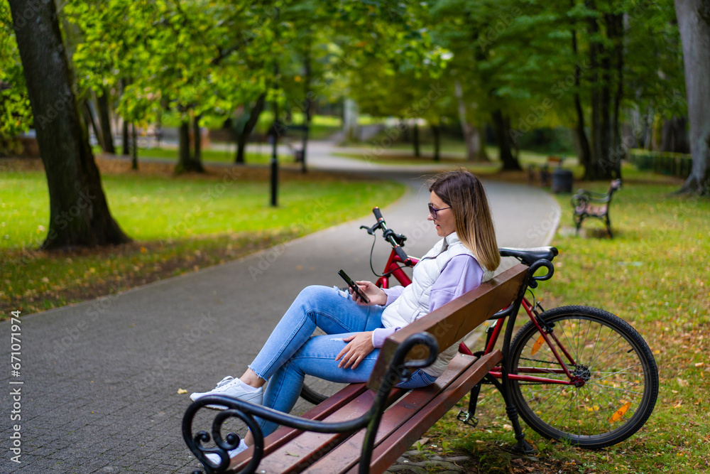 Beautiful woman resting on bench in city park using mobile phone
Beautiful woman resting on bench in city park using mobile phone