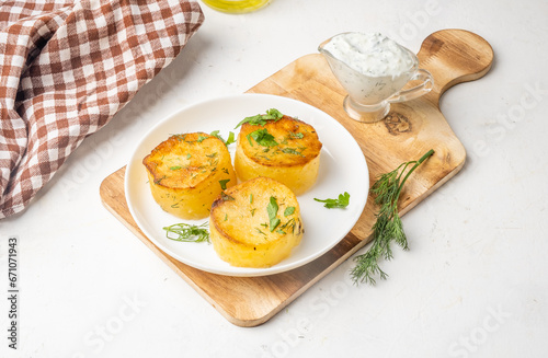 Potato fondant, melted potatoes in a white plate on a wooden board