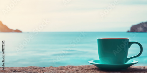 Coffee cup next to holiday beach, overlooking turquoise ocean 