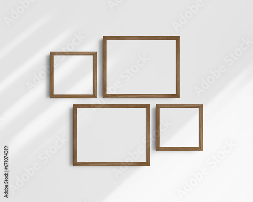 Gallery wall mockup set, 4 brown walnut wood frames. Clean, modern, and minimalist frame mockup. Two horizontal frames and two square frames, 14x11 (14:11), 8x8 (1:1) inches. White wall with shadows.