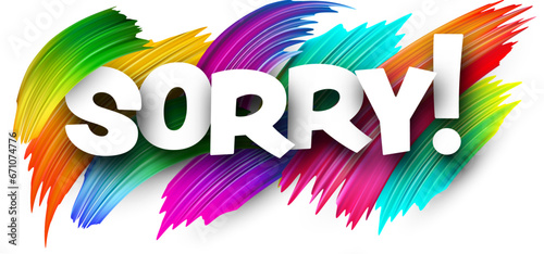 Sorry paper word sign with colorful spectrum paint brush strokes over white.