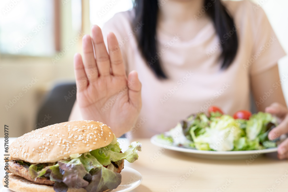 Beauty slim female body confuse hamburger. Woman in restaurant achieves weight loss goal for healthy life, crazy about thinness, thin waist, nutritionist. Diet, body shape. Beauty slim female body confuse hamburger. Woman in restaurant achieves weight loss goal for healthy life, crazy about thinness, thin waist, nutritionist. Diet, body shape.