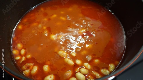 
Stirring the food on the stove. Hand stirring the cooked beans. stirring the food in the pot. food cooked on the stove.