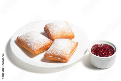 New Orleans Style Beignets, Fried Dough Fritters Topped with Powdered Sugar and Raspberry Sauce Isolated on White Background