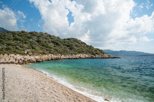 Fototapeta Naklejka Na Ścianę i Meble -  Beautiful pebble beach with azure turquoise sea. Beach vacation. Nature background
