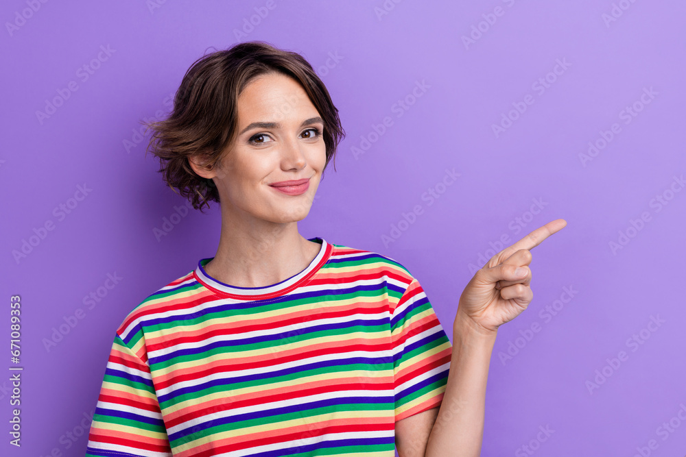 Portrait of cheerful pretty promoter lady directing finger empty space advertising novelty product isolated purple color background Portrait of cheerful pretty promoter lady directing finger empty space advertising novelty product isolated purple color background