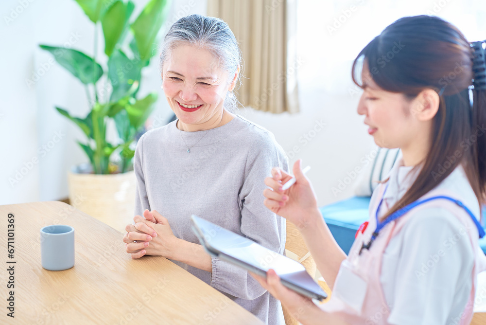 会話するシニア女性とエプロン姿の若い女性 会話するシニア女性とエプロン姿の若い女性