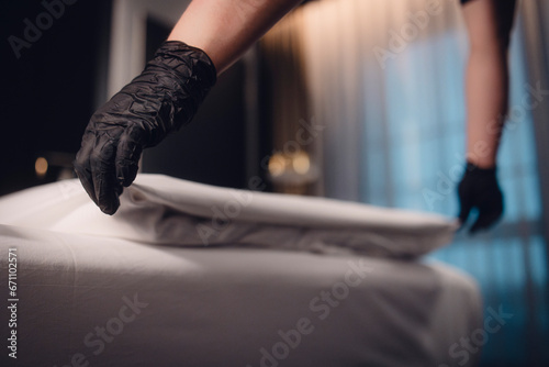 Reinigungskraft macht die Betten im Hotelzimmer