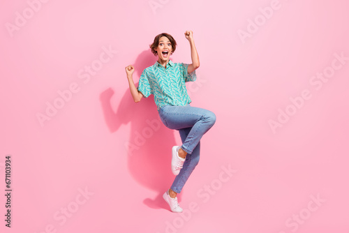 Full size portrait of overjoyed satisfied girl raise fists shout yes hooray attainment isolated on pink color background