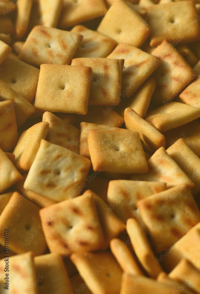 Background texture of small edible squares baked from dough and sprinkled with salt. A lot of salt cracker Background texture of small edible squares baked from dough and sprinkled with salt. A lot of salt cracker