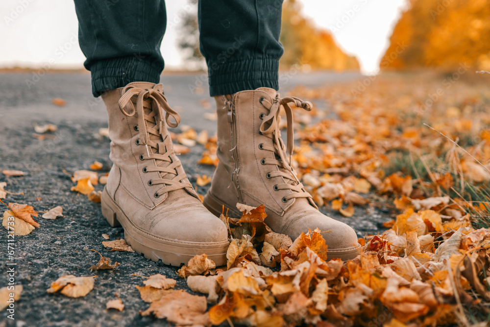 A man walks along an autumn road, boots close-up A man walks along an autumn road, boots close-up