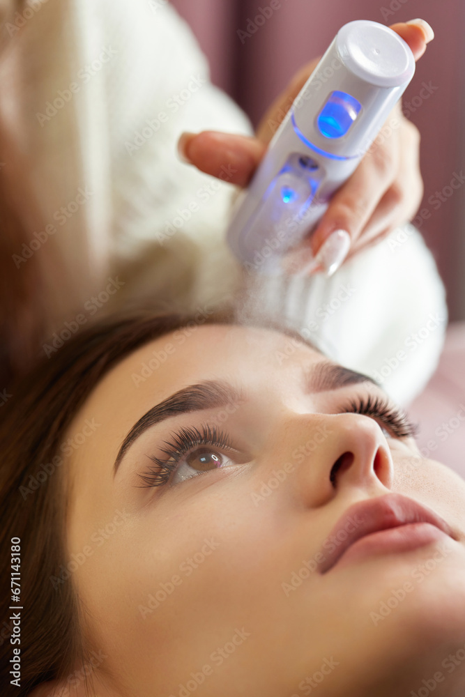 cosmetologist using primer spray for eyelash extension procedure in salon cosmetologist using primer spray for eyelash extension procedure in salon