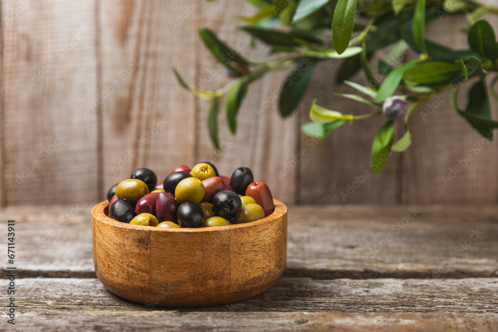 A set of green, red and black olives on background. Various types of olives in bowls and fresh olive leaves. Vegan. Olive fruits. Place for text. Copy space. A set of green, red and black olives on background. Various types of olives in bowls and fresh olive leaves. Vegan. Olive fruits. Place for text. Copy space.