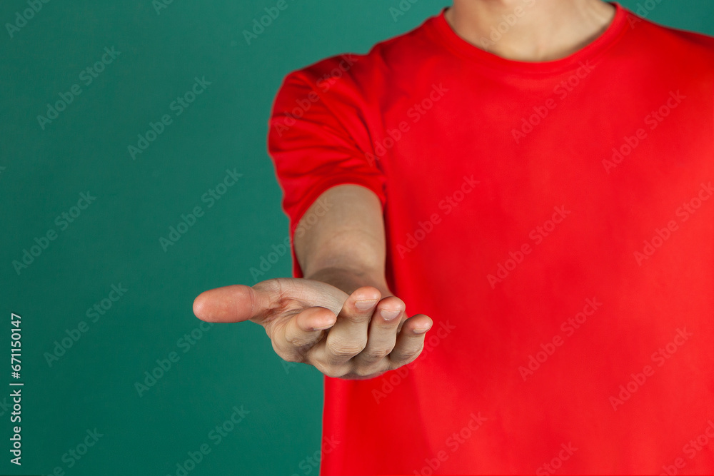 Chico vestido de papa noel en navidad mostrando con sus manos. hombre de rojo y blanco sobre fondo verde - obrazy, fototapety, plakaty 
