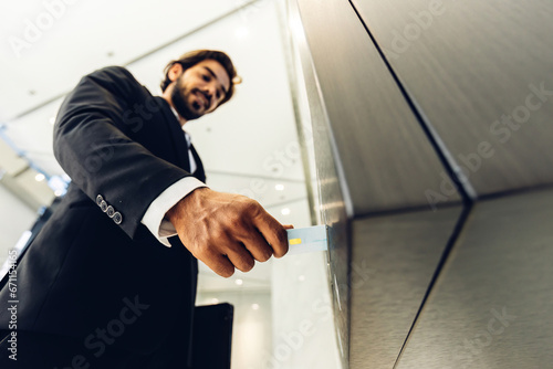 Businessman using card to open automatic gate machine in office building. Male using smart card to open automatic gate machine in office building. Working routine concept.