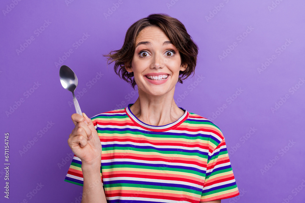 Photo of funky cheerful girl dressed trendy clothes showing spoon wanting dinner isolated on purple color background Photo of funky cheerful girl dressed trendy clothes showing spoon wanting dinner isolated on purple color background