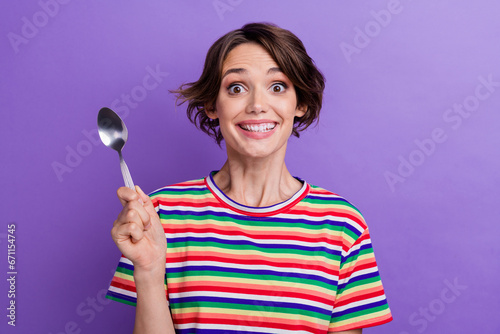 Photo of funky cheerful girl dressed trendy clothes showing spoon wanting dinner isolated on purple color background
