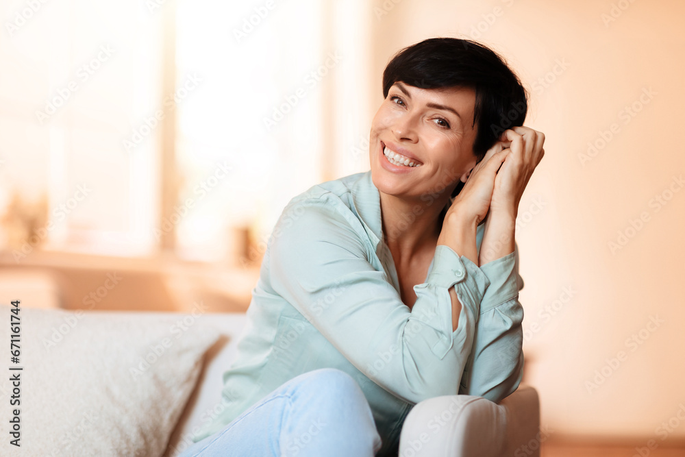Portrait of smiling middle aged woman on couch at home Portrait of smiling middle aged woman on couch at home