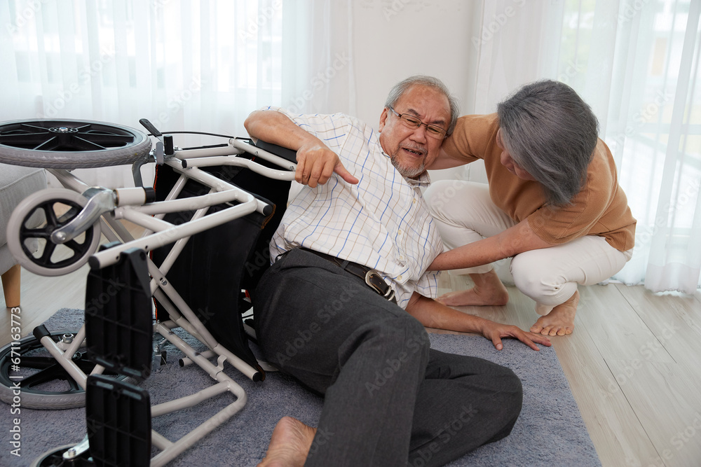 senior man fallen from wheelchair and senior woman helping him senior man fallen from wheelchair and senior woman helping him