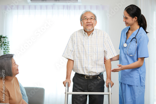 nurse or caregiver helping senior man walking with a walker and senior woman support him at home © offsuperphoto