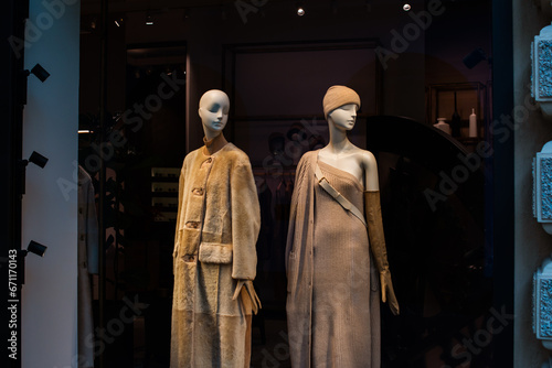 Fancy clothing in a store in European shops. Display of a clothing store, bright and fashionable window of modern fashion. Beautiful fur clothing in a luxury store window.