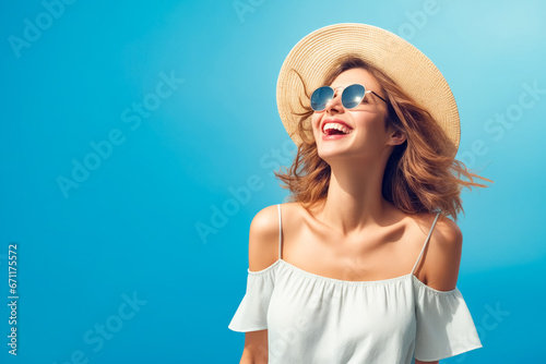 Woman wearing hat and sunglasses smiling at the camera.