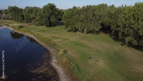 Aerial Footage of Pond in Montana with man walking dogs, Summertime