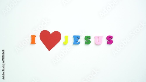I Love Jesus text from colorful wooden letters and a beating paper red heart. photo