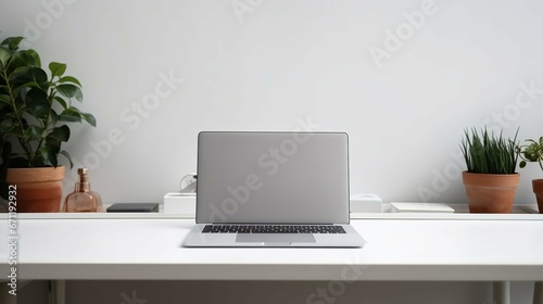 Front view laptop on white table. Nearby is document paper, pencil holder. © Ahtesham