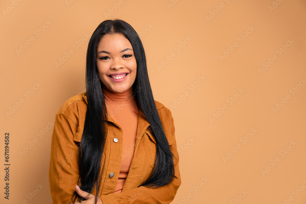 cheerful black woman smiling and standing in beige studio background. joy, people concept. cheerful black woman smiling and standing in beige studio background. joy, people concept.