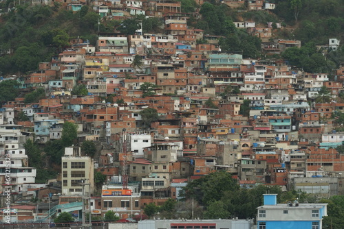Suburb with poor family houses of La Guaira town near Caracas showing poverty and is situated on hill near commercial merchant port. View from container terminal.