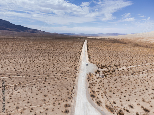 фотографія Aerial views of a dirt road crossing an immense desert, where there is only an insignificant van for miles