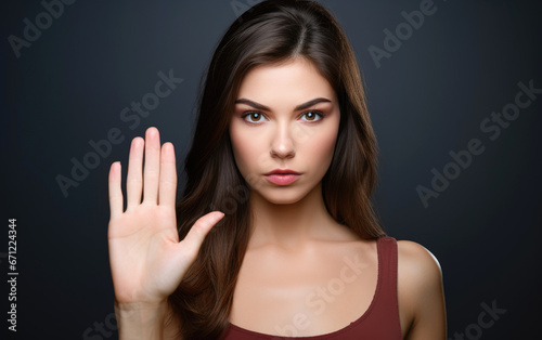 A beautiful serious woman saying stop, showing her palm to the camera