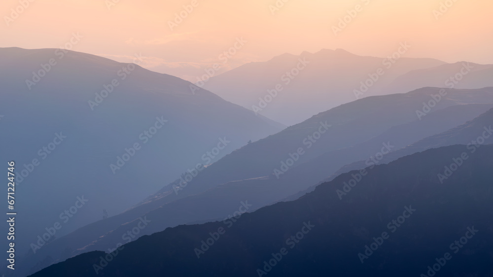 Beautiful layered blue mountains, transitioning into the sunset horizontal