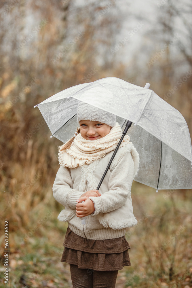 Portrait of a preschool girl standing in the park under an umbrella in the fall, smiling. Portrait of a preschool girl standing in the park under an umbrella in the fall, smiling.
