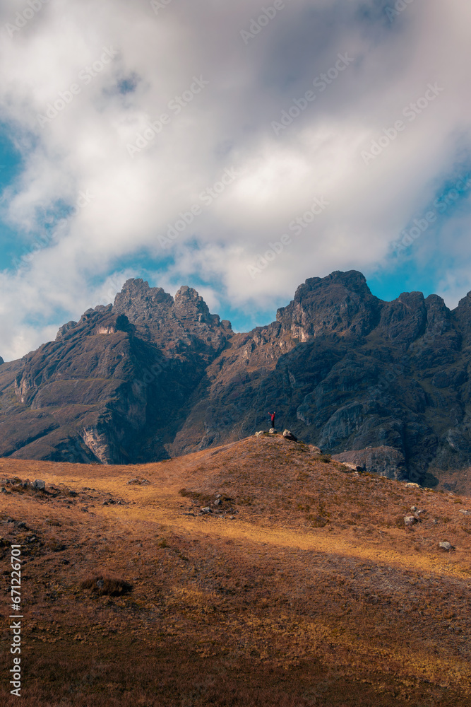 Man standing on a big mountain, waving, in the highlands, cloudy day Man standing on a big mountain, waving, in the highlands, cloudy day