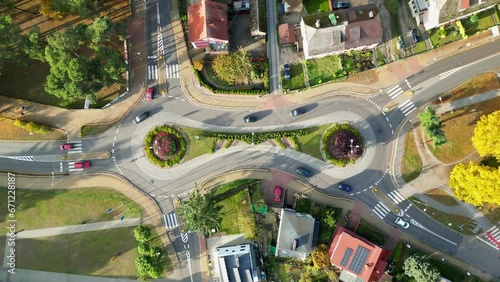 cars going on a originally interestig shaped roundabout, top-down drone footage