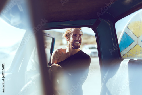 Radiant man in car with surfboard ready for the waves photo